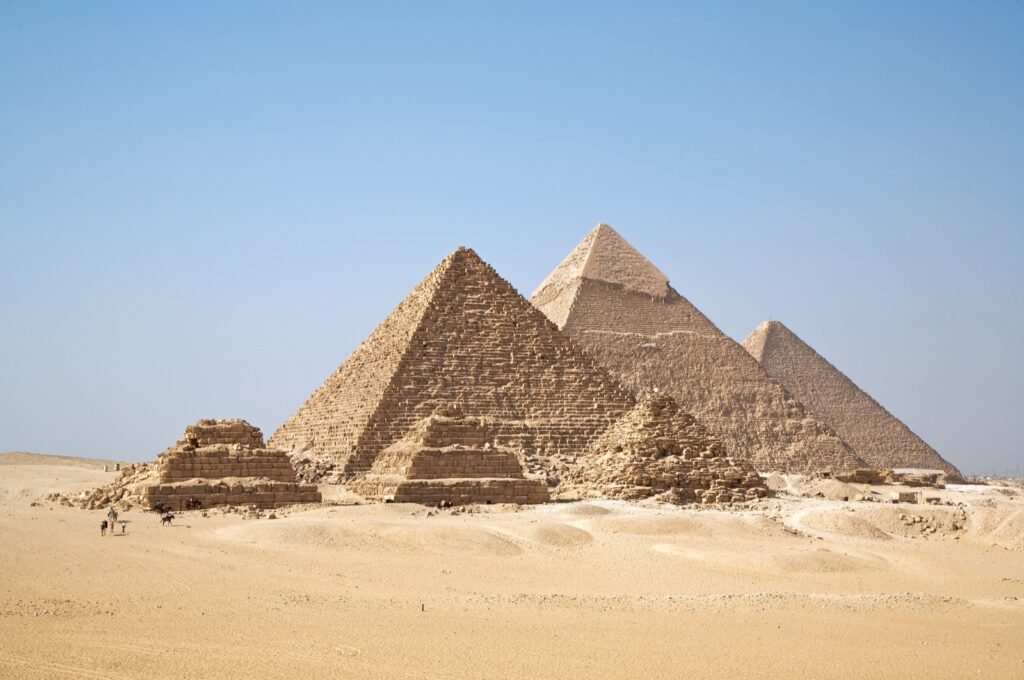 Pyramides principales et pyramides subsidiaires de Gizeh sous un ciel bleu.