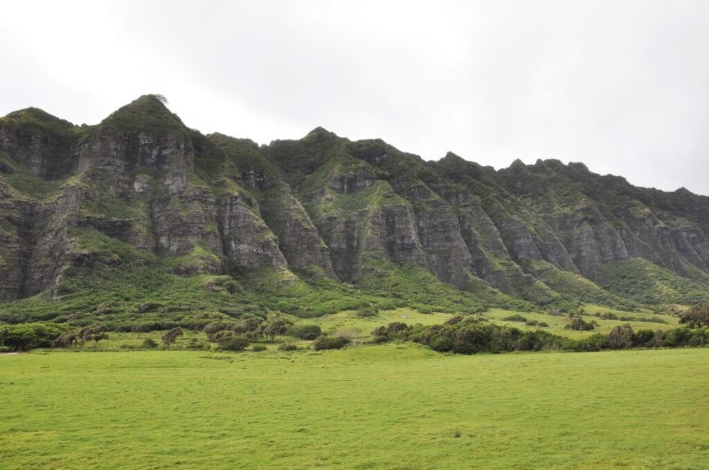 Crêtes escarpées couvertes de végétation au-dessus de la prairie de Kualoa, sur Oʻahu.